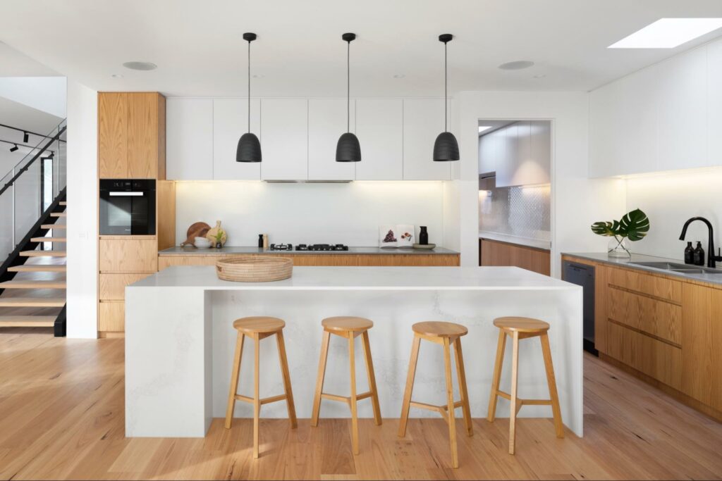 modern kitchen design with wooden stools and pot lights above island